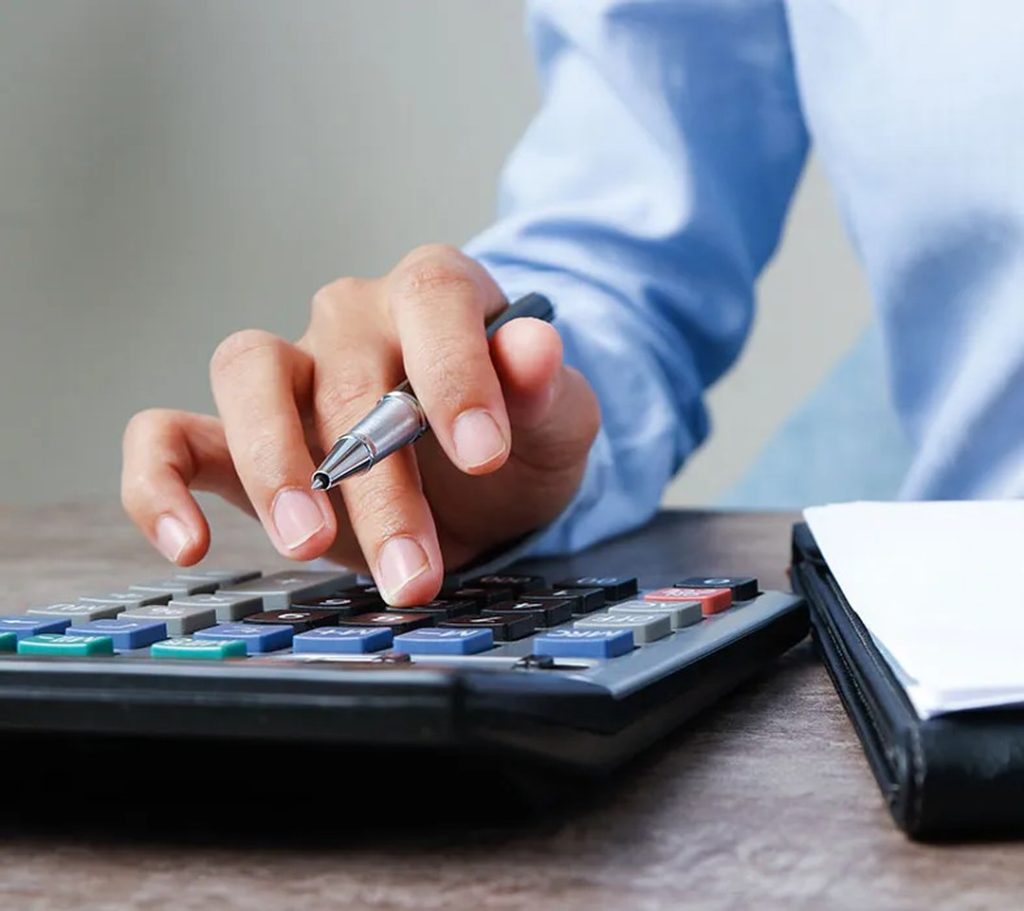 Manos de un profesional usando una calculadora junto a documentos contables